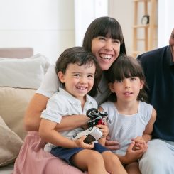 Famiglia sorridente con due bambini seduta sul divano